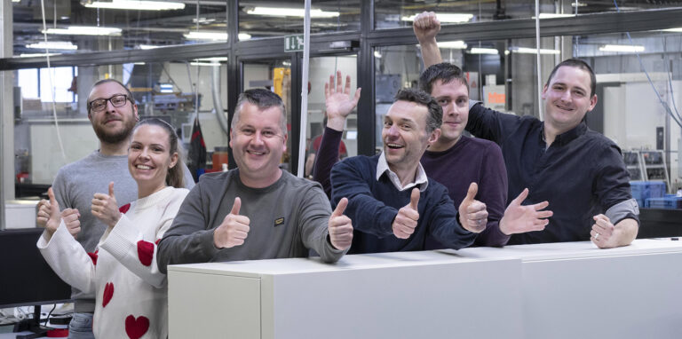 Een groep collega's van de technische dienst steekt enthousiast de duimen in de lucht.