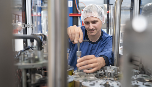 Automation Engineer werkt aan een bedrukkingsmachine van kunststofproducent Hubert De Backer nv.
